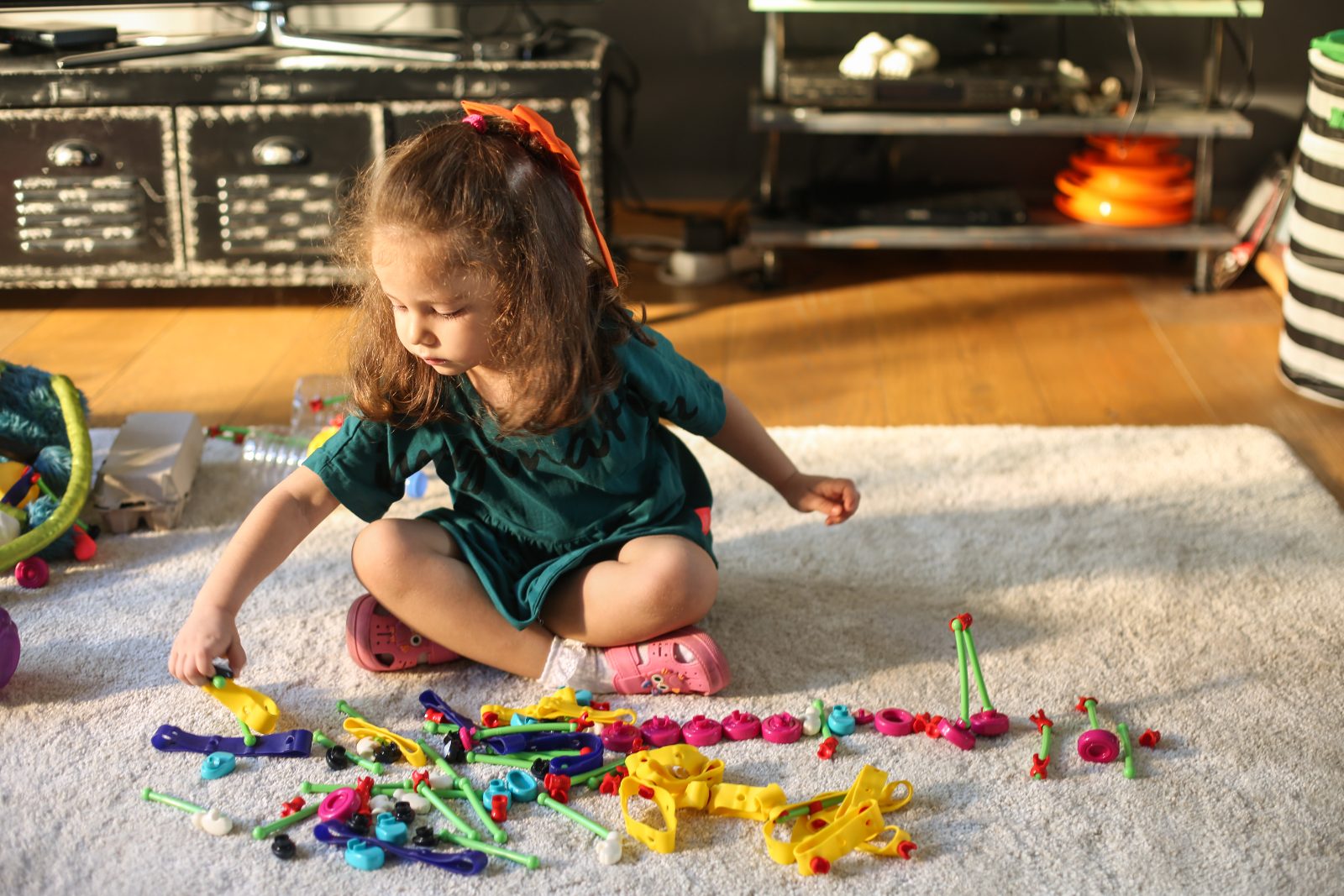 A girl laying out a long row of Toyi creations