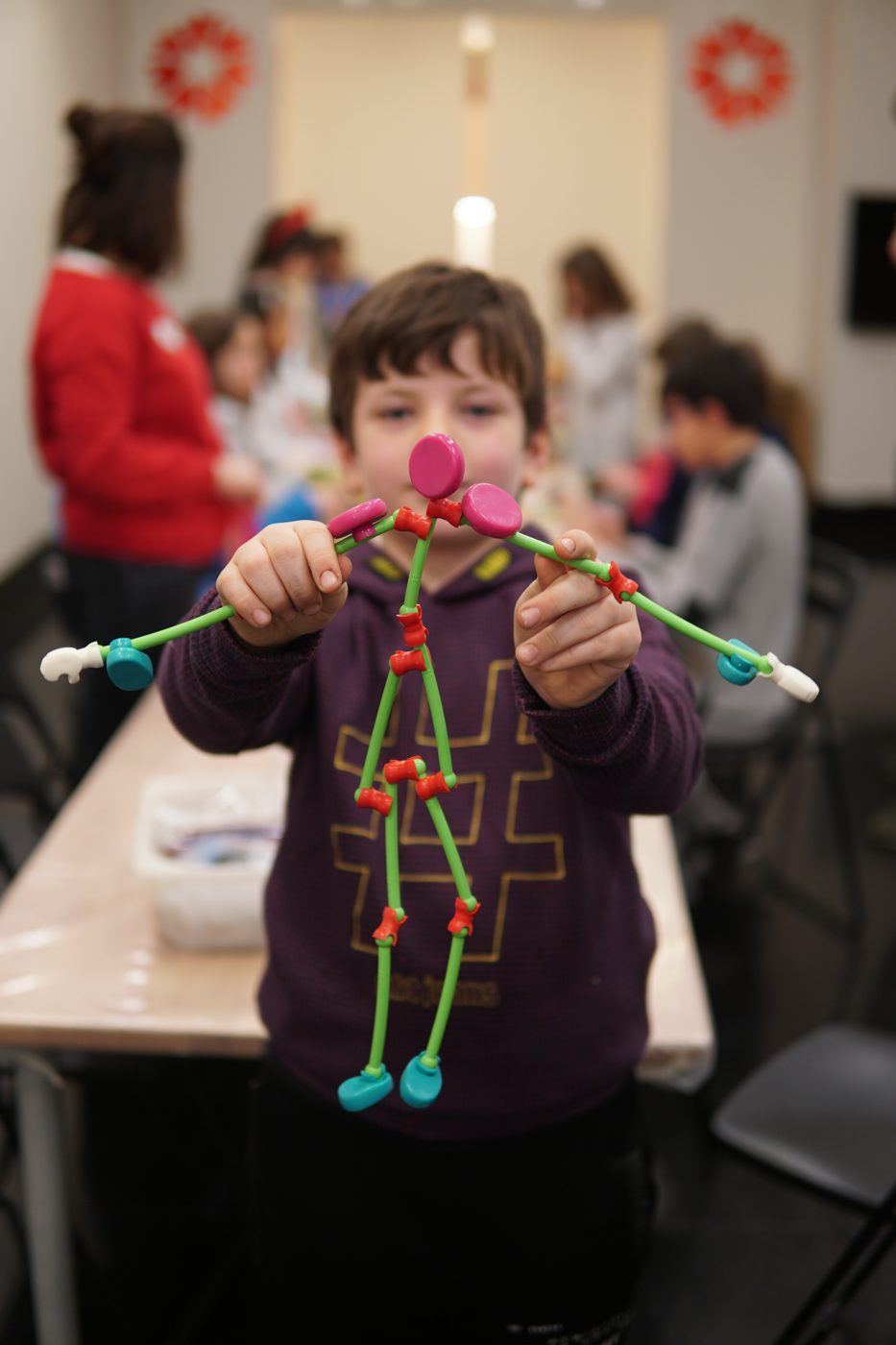 A child holding up a structure built with Toyi sticks